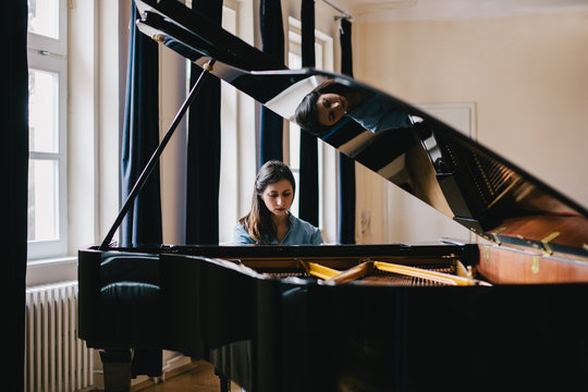 Brunette woman playing piano indoor