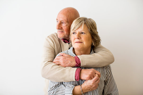 Portrait of an elderly couple embracing together at home.