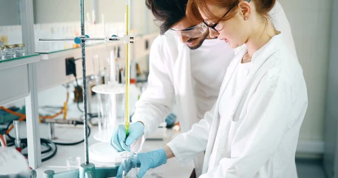 Young students of chemistry working in laboratory