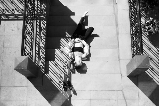 A Black And White Film Portrait Of A Young Woman Lying On The Stairs Made With Old Analog Camera