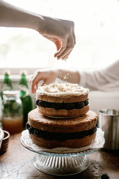 Two tierd naked layer cake is decorated by two females