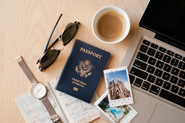 Office desk with a laptop, passports, Polaroid pictures and coffee