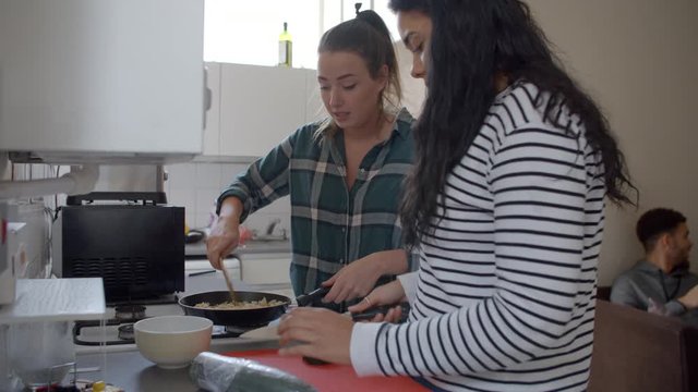 Group Of Students Cooking Meal In Shared House 