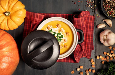 Pumpkin creme soup served with croutons, crushed nuts, parsley and cream