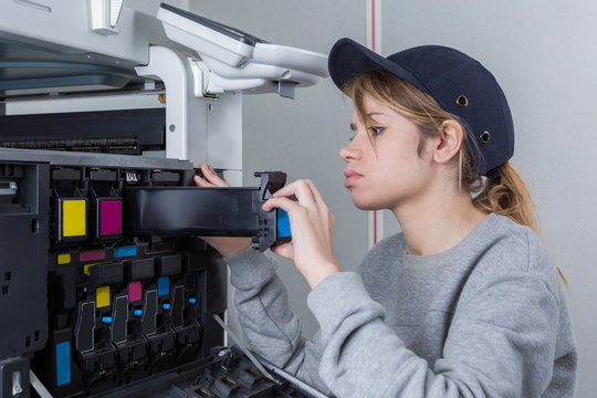 young professional technician woman performing toner change and printer maintenance