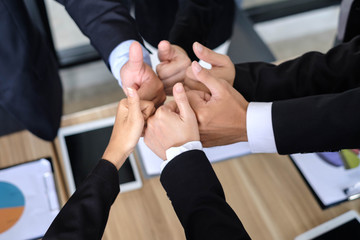 Asian business people joining hands with colleagues together at meeting time for develop job to success, business colleagues teamwork concept