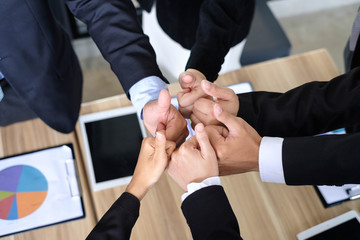 Asian business people joining hands with colleagues together at meeting time for develop job to success, business colleagues teamwork concept