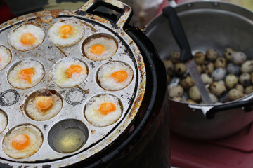 Grilled quail eggs in a pan pits