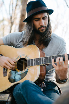 Cool looking musician playing his acoustic guitar