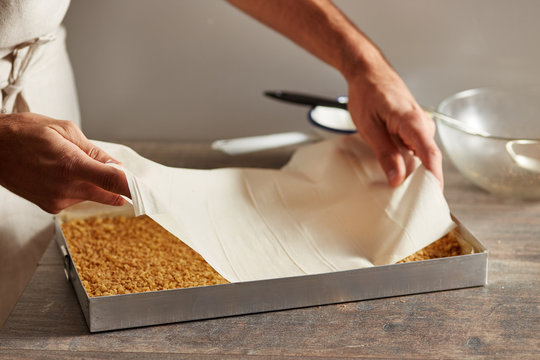 Chef placing phyllo sheet into baking pan