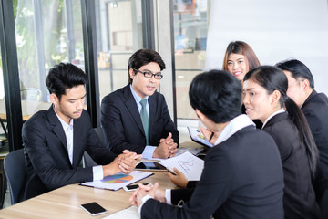 Asian business people meeting time,manager listening his staff brainstorming discussing about new startup project together in conference room at office,business colleagues teamwork concept