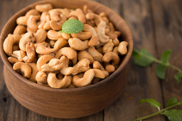 cashew nuts in wood bowl on old wood table

