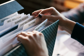 Taxes: Woman Digging Through Tax File Folder For Forms
