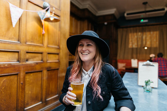 Woman drinking beer in a pub