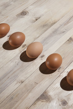 Line of eggs against a wooden background.