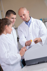 man with two young students in white jackets