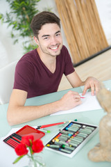 young man drawing pictures in studio