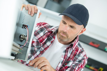 young repairer working with screwdriver in service center