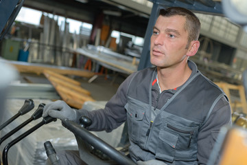 man driving a forklift inside warehouse