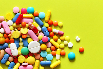 Colorful pills on a green and yellow background