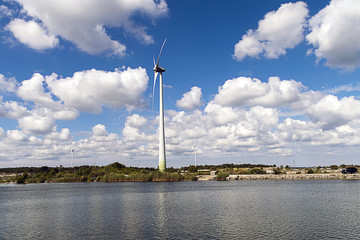 Fototapeta na wymiar Wind turbine and a blue sky with clouds