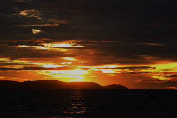 Beautiful blazing sunset landscape at black sea and orange sky above it with awesome sun golden reflection on calm waves as a background. Amazing summer sunset view on the beach