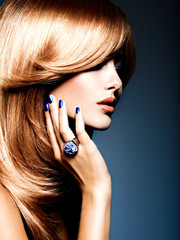 Face of a beautiful woman with sapphire jewelry ring on finger