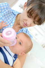 mother feeding baby baby infant eating milk from bottle