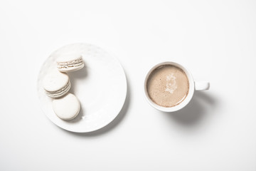 Obraz na płótnie Canvas Three beige white macaroon cookies and coffee