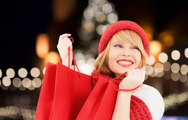 happy woman with shopping bags over christmas tree