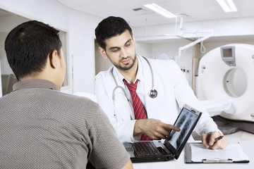 Doctor with his patient looking at chest x-ray