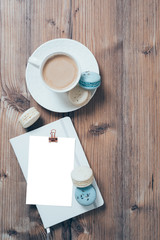 Cup of coffee and blue macaroons on wooden table background