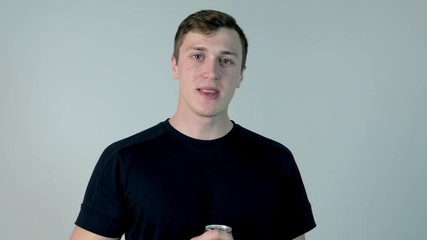 Young man drinking soda. Young man in black shirt drinking soda, on a white background - Powered by Adobe