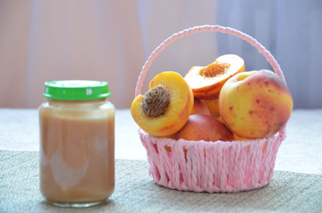 baby food, baby fruit mashed in a glass jar, peach, beautiful peaches in a basket, children's toy