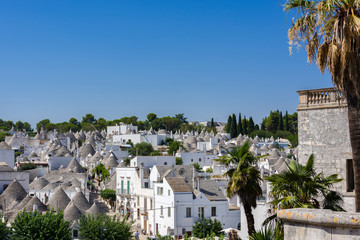 Beautiful town of Alberobello with trulli houses among green plants and flowers