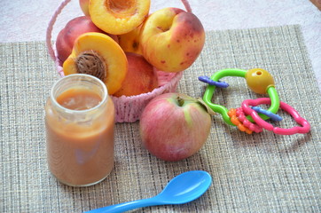 baby food, baby fruit mashed in a glass jar, peach, beautiful peaches in a basket, children's toy. apple