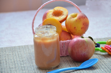 baby food, baby fruit mashed in a glass jar, peach, beautiful peaches in a basket, children's toy. apple