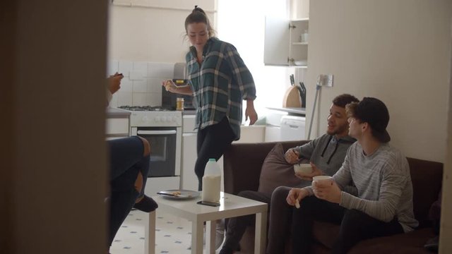 Group Of Students Eating Breakfast In Shared House 