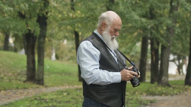 Senior man takes a photo of nature in park