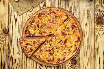 Hot pizza slice with melting cheese on a rustic wooden table.pepperoni pizza,Hot Homemade Pepperoni Pizza Ready to Eat,Supreme Pizza lifted slice