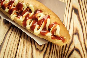 Barbecue Grilled Hot Dog with sauce,Hot Dog With Yellow Mustard,Onion,Pickles and French Fries,Tasty hot-dogs with vegetables on wooden background, close up,hot dogs with mustard, ketchup and relish