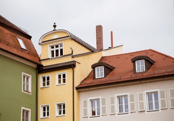 Fototapeta na wymiar Walls, roofs and windows of typical German town buildings in Regensburg,