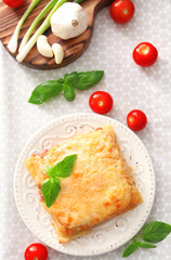 Plate with tasty lasagna on table