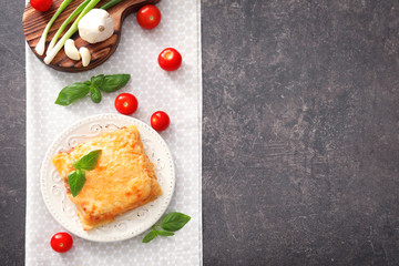 Plate with tasty lasagna on grey background