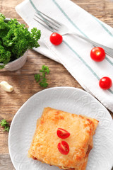 Plate with tasty lasagna on table