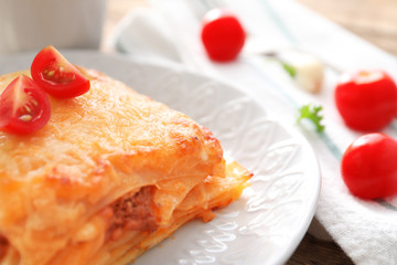 Plate with tasty lasagna on table