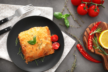 Plate with tasty lasagna on table