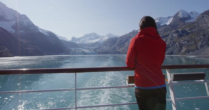 Alaska cruise ship passenger tourist looking at landscape in Glacier Bay National Park, USA. Woman on travel sailing Inside Passage enjoying view of Johns Hopkins Glacier.