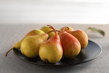 Ripe pears on black plate