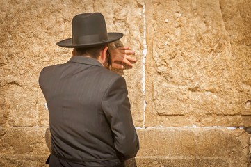 Religious Jewish man seen from the back, Orthodox Jew praying at the Western wall (Wailing wall), Jewish prayer. Orthodox Judaism, Jewish holidays stock image.